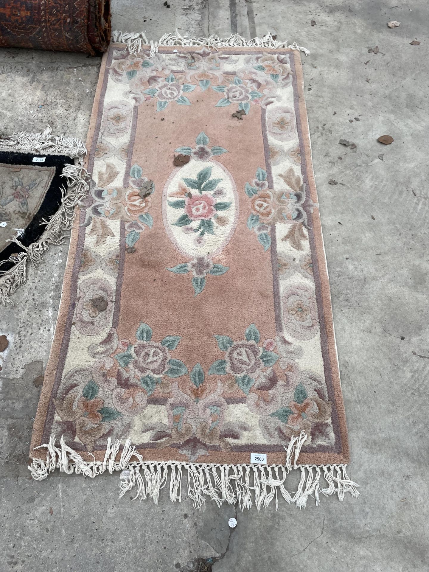A PEACH PATTERNED FRINGED RUG