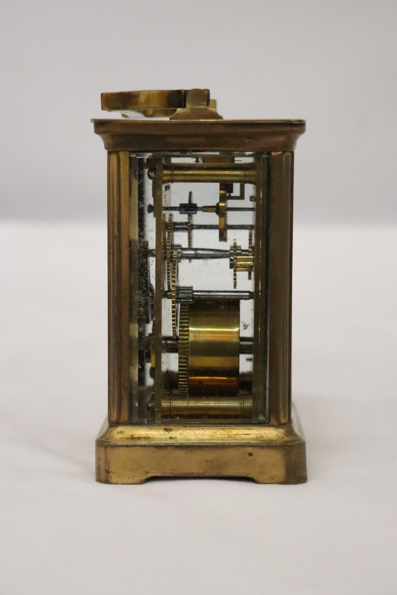 A VINTAGE BRASS CARRIAGE CLOCK WITH BEVELED GLASS SECTIONS TO REVEAL UPPER ESCAPEMENT AND INNER - Image 4 of 5