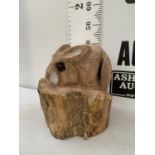 A WOODEN CARVED RABBIT SCULPTURE ON TREE TRUNK APPROX 45CM IN HEIGHT NOVAT