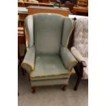 A SHACKLETONS FURNITURE WINGED FIRESIDE CHAIR ON FRONT CABRIOLE LEGS