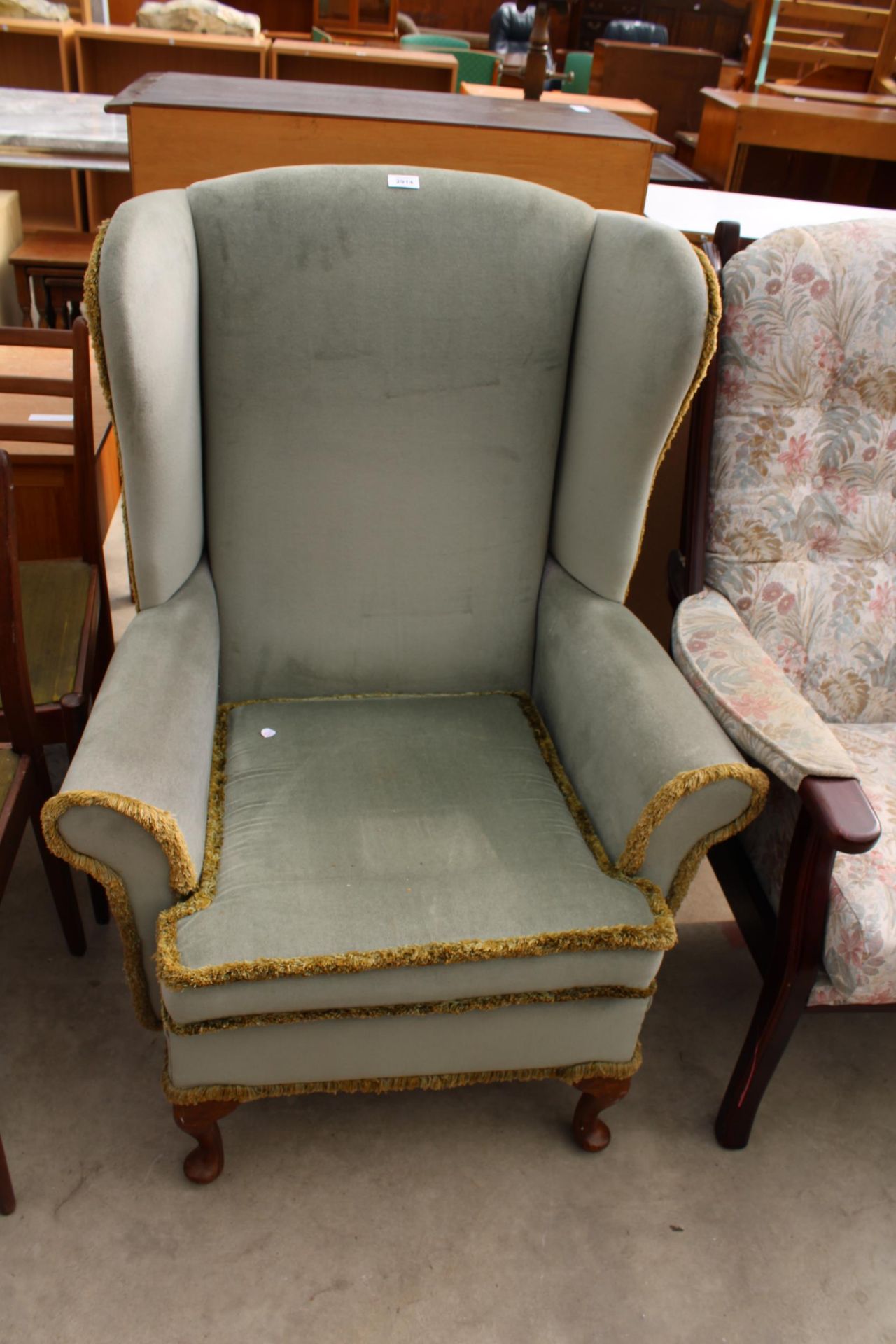 A SHACKLETONS FURNITURE WINGED FIRESIDE CHAIR ON FRONT CABRIOLE LEGS