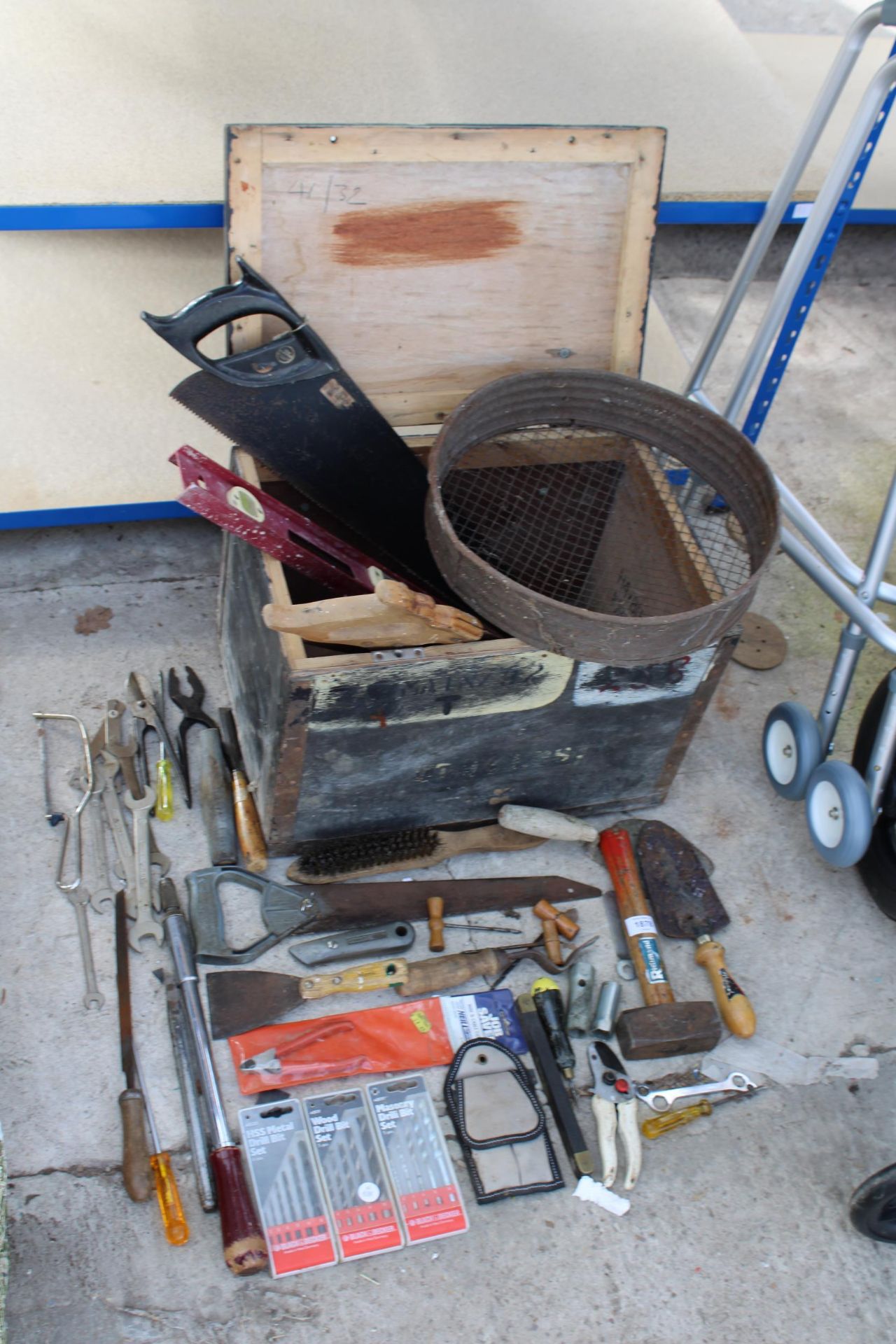 A WOODEN TOOL CHEST WITH AN ASSORTMENT OF HAND TOOLS TO INCLUDE SPANNERS, HAMMERS AND SAWS ETC