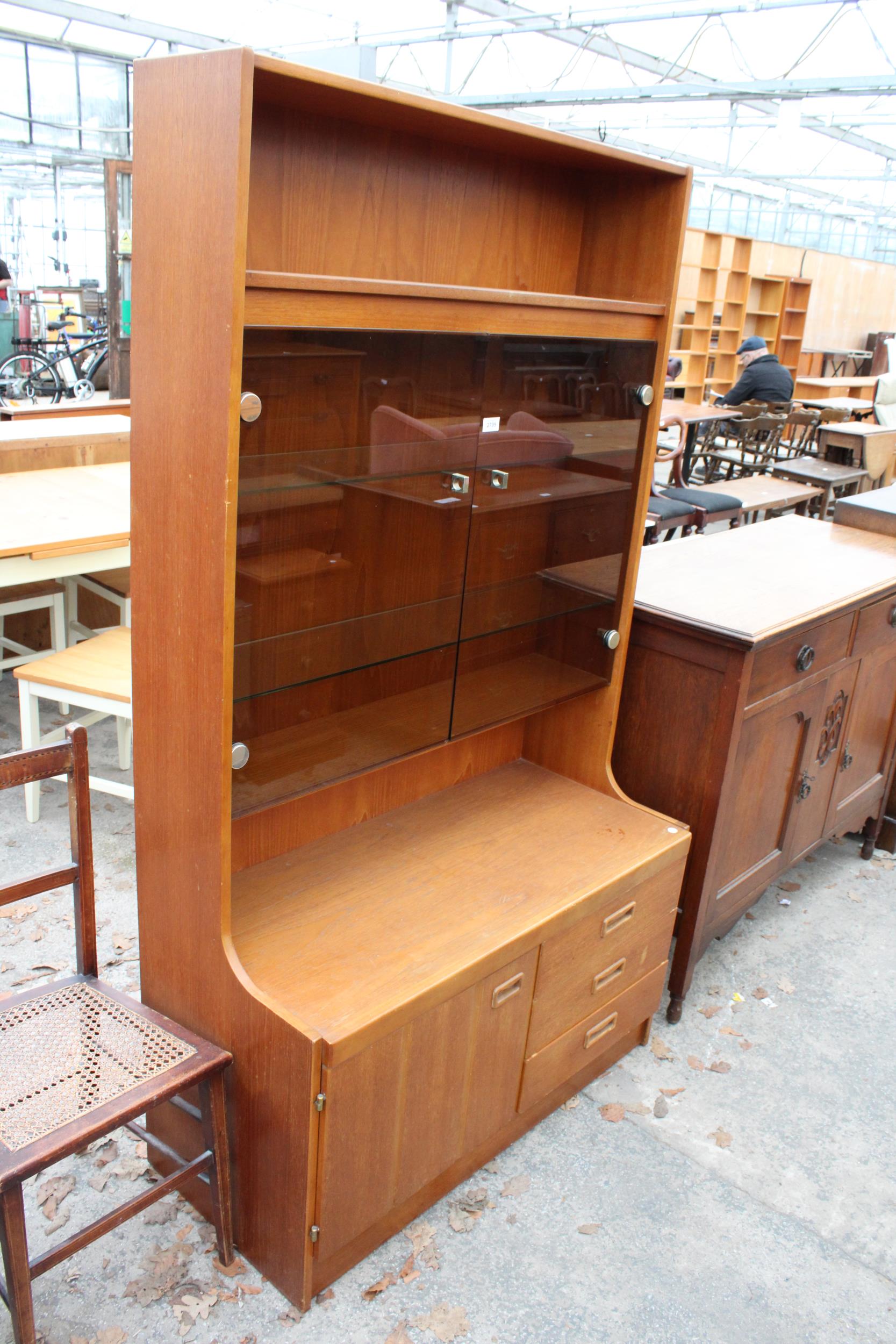 A RETRO TEAK UNIT WITH SMOKED GLASS DOORS, CUPBOARD AND DRAWERS TO BASE. 39.5" WIDE