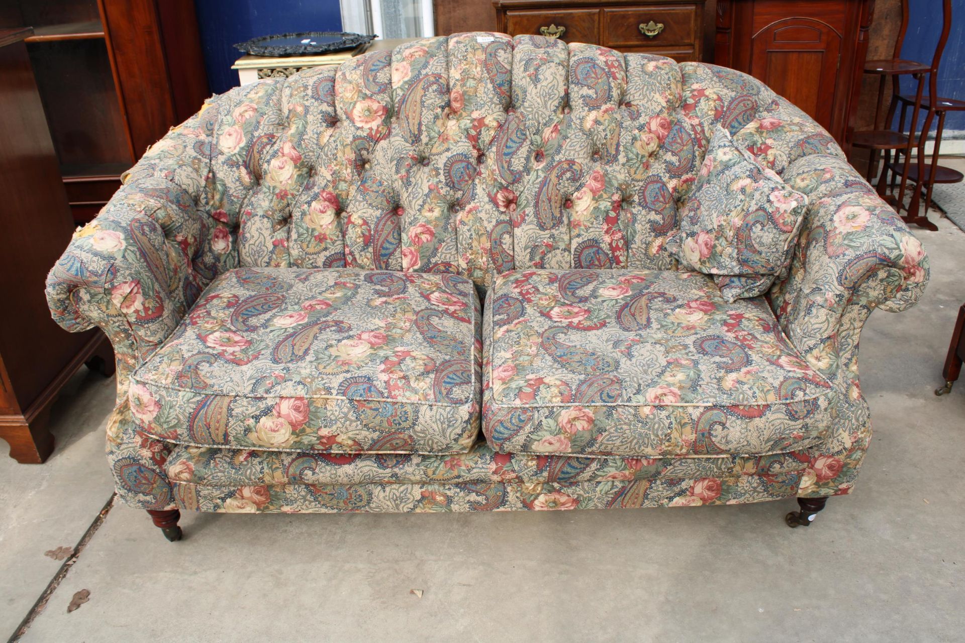 A VICTORIAN STYLE TWO SEATER BUTTON BACK SETTEE ON TURNED FRONT LEGS