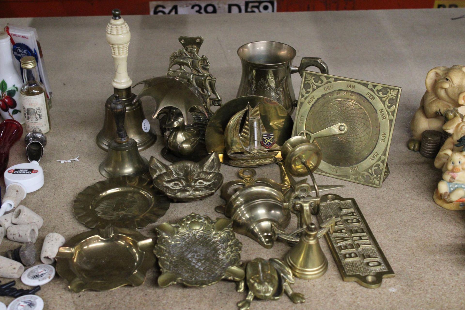 A COLLECTION OF BRASSWARE TO INCLUDE BELLS, PIN DISHES, A CALENDAR, WALL SCONCE, ETC