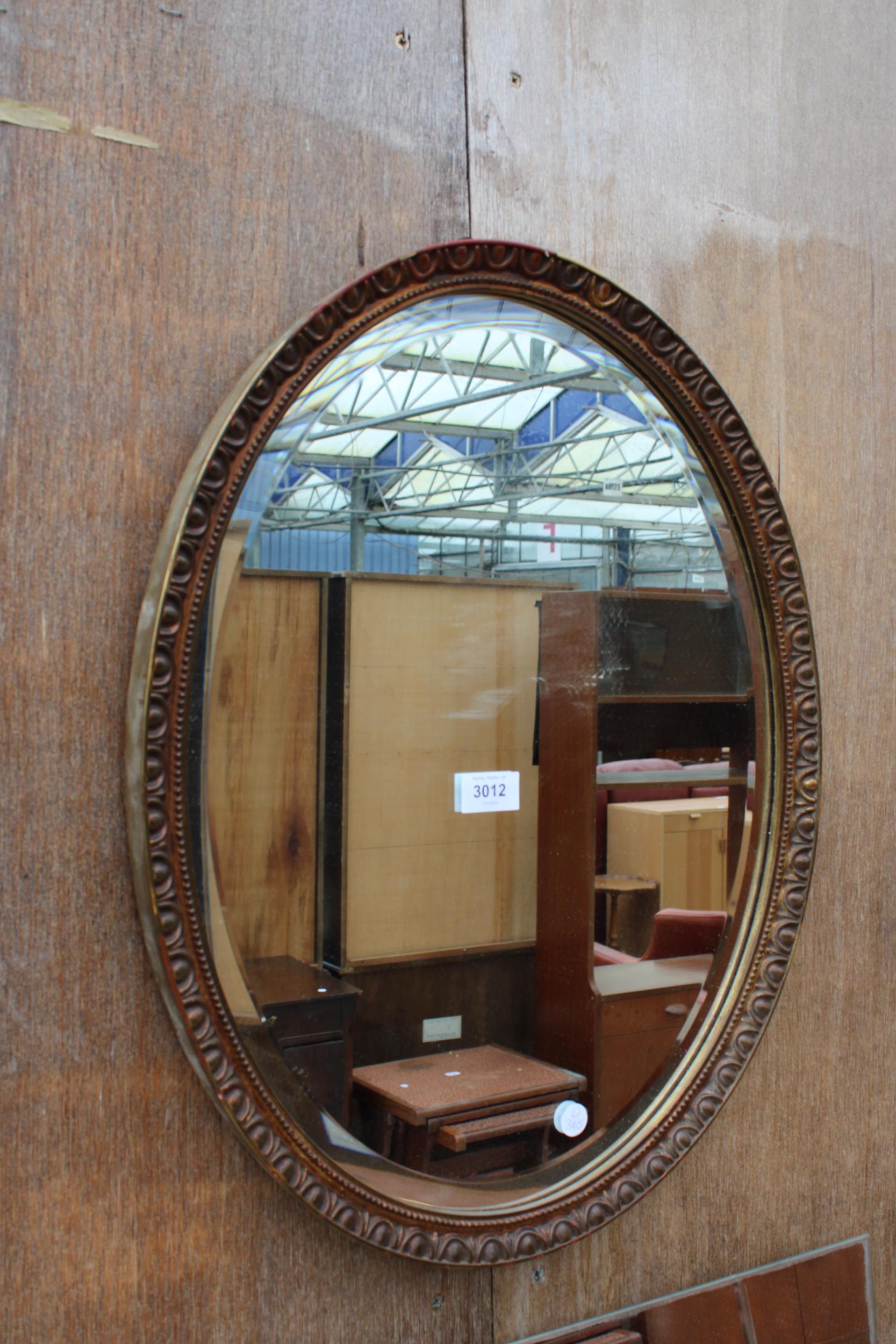 AN OVAL BEVEL EDGE WALL MIRROR 23" X 18"