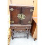 AN EARLY 20TH CENTURY OAK JACOBEAN STYLE COCKTAIL CABINET ENCLOSING SLIDES AND A SINGLE DRAWER ON