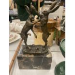 A BRONZE BOXING HARES ON MARBLE BASE SIGNED
