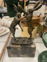 A BRONZE BOXING HARES ON MARBLE BASE SIGNED