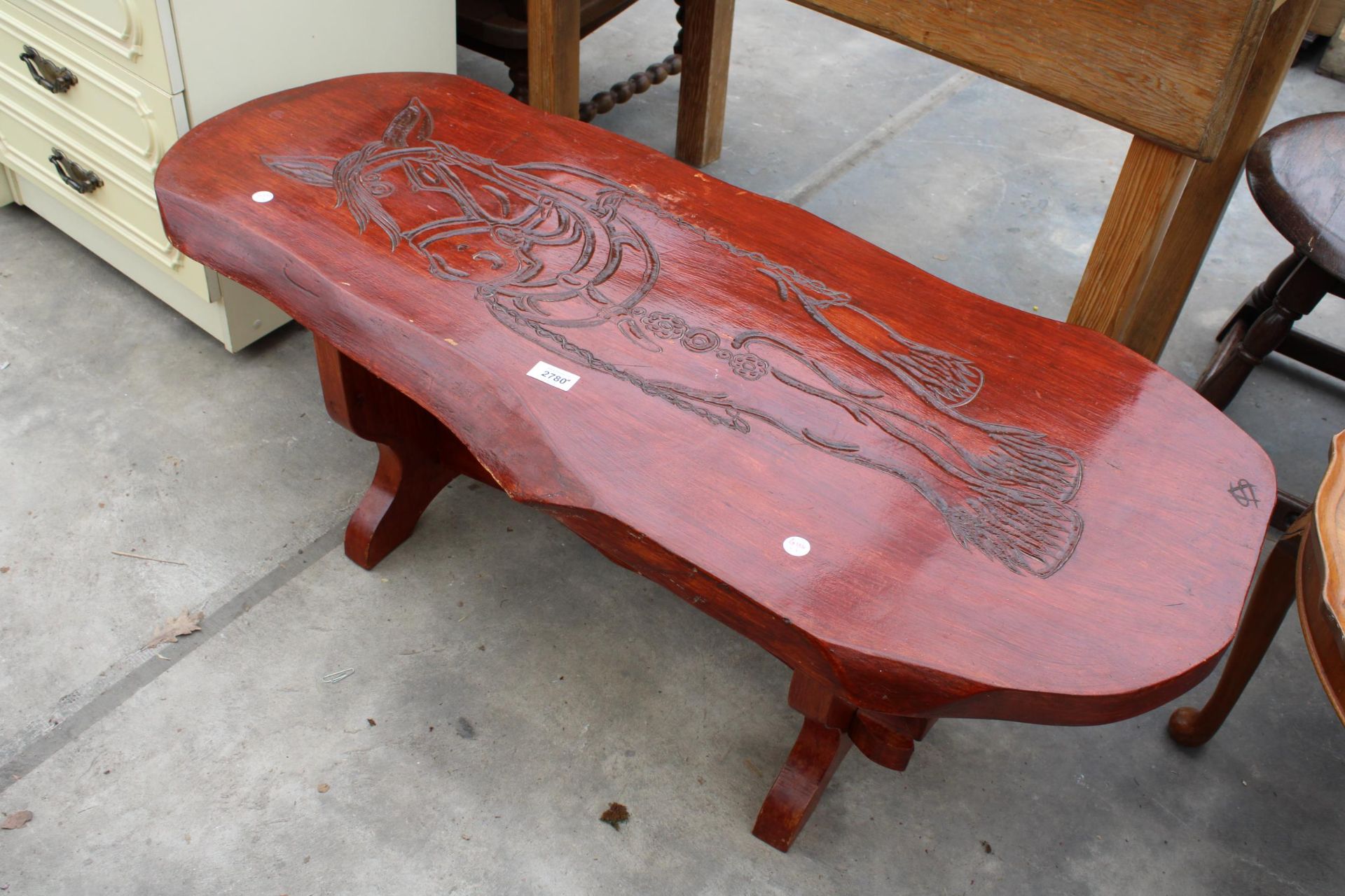 A STAINED ELM COFFEE TABLE, THE TOP HAVING CARVING OF A HORSE, SIGNED A.S, 42" X 18"
