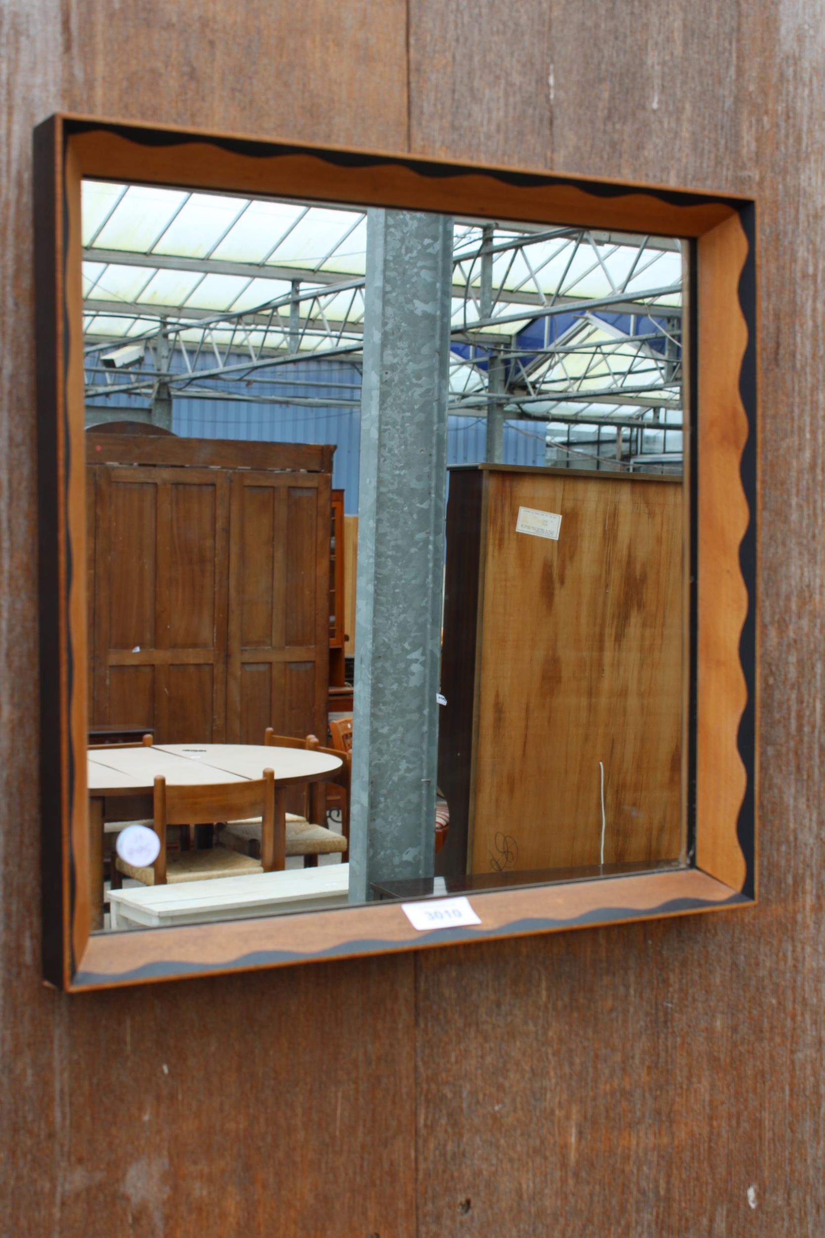 A WALL MIRROR WITH BLACK PAINTED DECORATION 16"SQUARE