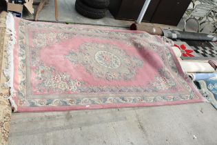 A LARGE PINK PATTERNED FRINGED RUG