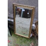 A GILT FRAMED BEVEL EDGE WALL MIRROR 27" X 15"