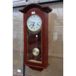 A WOODEN CASED CHIMING 31 DAY WALL CLOCK
