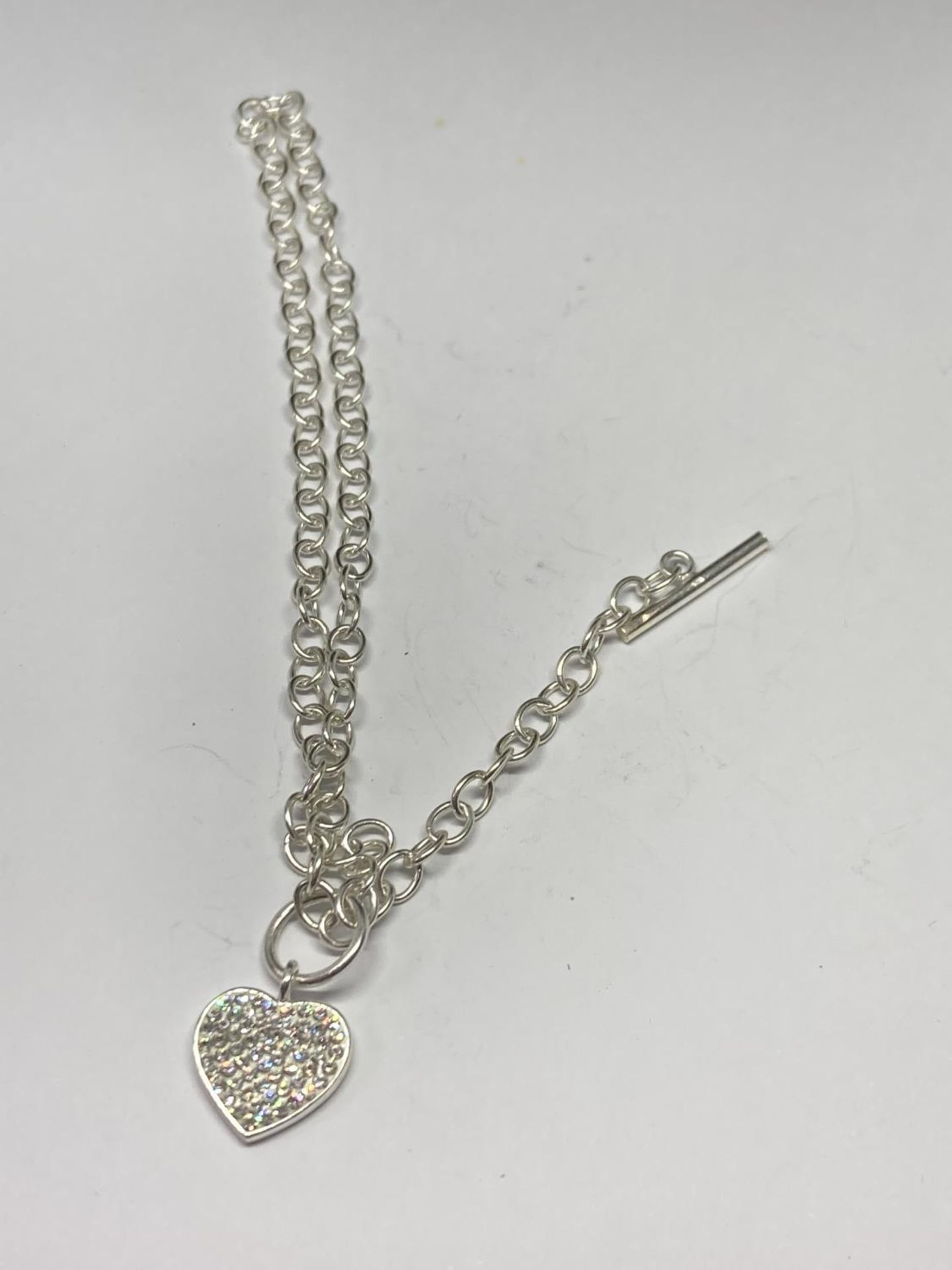 A SILVER T BAR NECKLACE WITH HEART CHARM LENGTH 18"