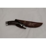 A HUNTING KNIFE IN A LEATHER SHEATH
