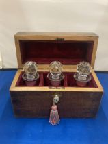 A VINTAGE LINED WOODEN CHEST WITH THREE CRANBERRY GLASS BOTTLES COMPLETE WITH KEY