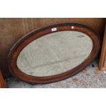 A MID 20TH CENTURY OVAL OAK BEVEL EDGED MIRROR 34" X 24"