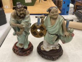 TWO ORIENTAL CERAMIC FIGURES ON WOODEN STANDS, HEIGHTS 23CM