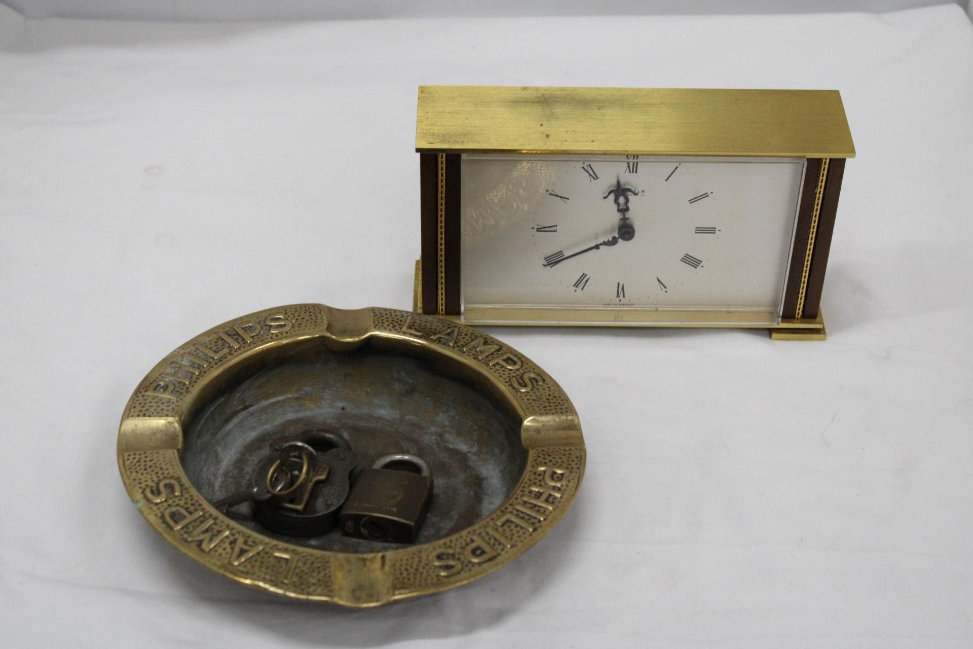 A VINTAGE BRASS, GERMAN MANTLE CLOCK, A LARGE PHILIPS LAMPS ASHTRAY PLUS TWO PADLOCKS