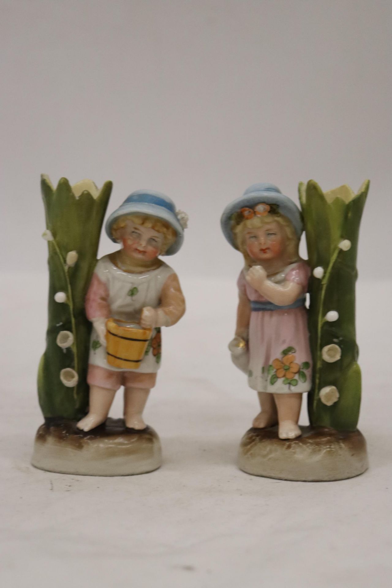 TWO VINTAGE GERMAN FAIRINGS TO INCLUDE A GIRL WITH JUG VASE AND A GIRL WITH BASKET VASE GOOD COLOURS