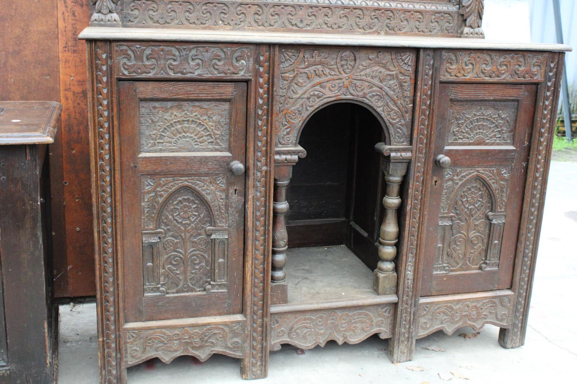 A HEAVILY CARVED GOTHIC OAK SIDEBOARD WITH DEER HUNTING SCENE AND MYTHICAL FIGURE, RAISED BACK, - Image 4 of 5