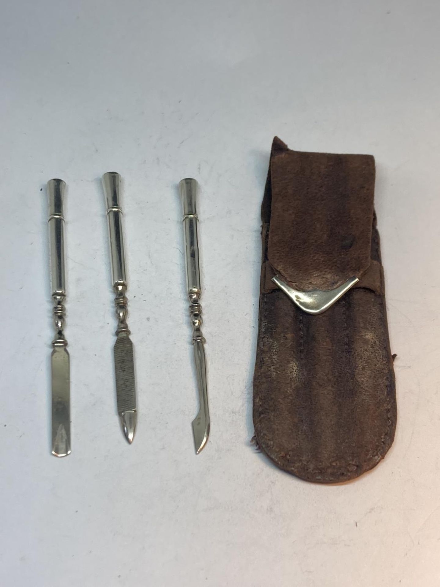 A MARKED STERLING SILVER THREE PIECE MANICURE SET IN A LEATHER AND SILVER CASE