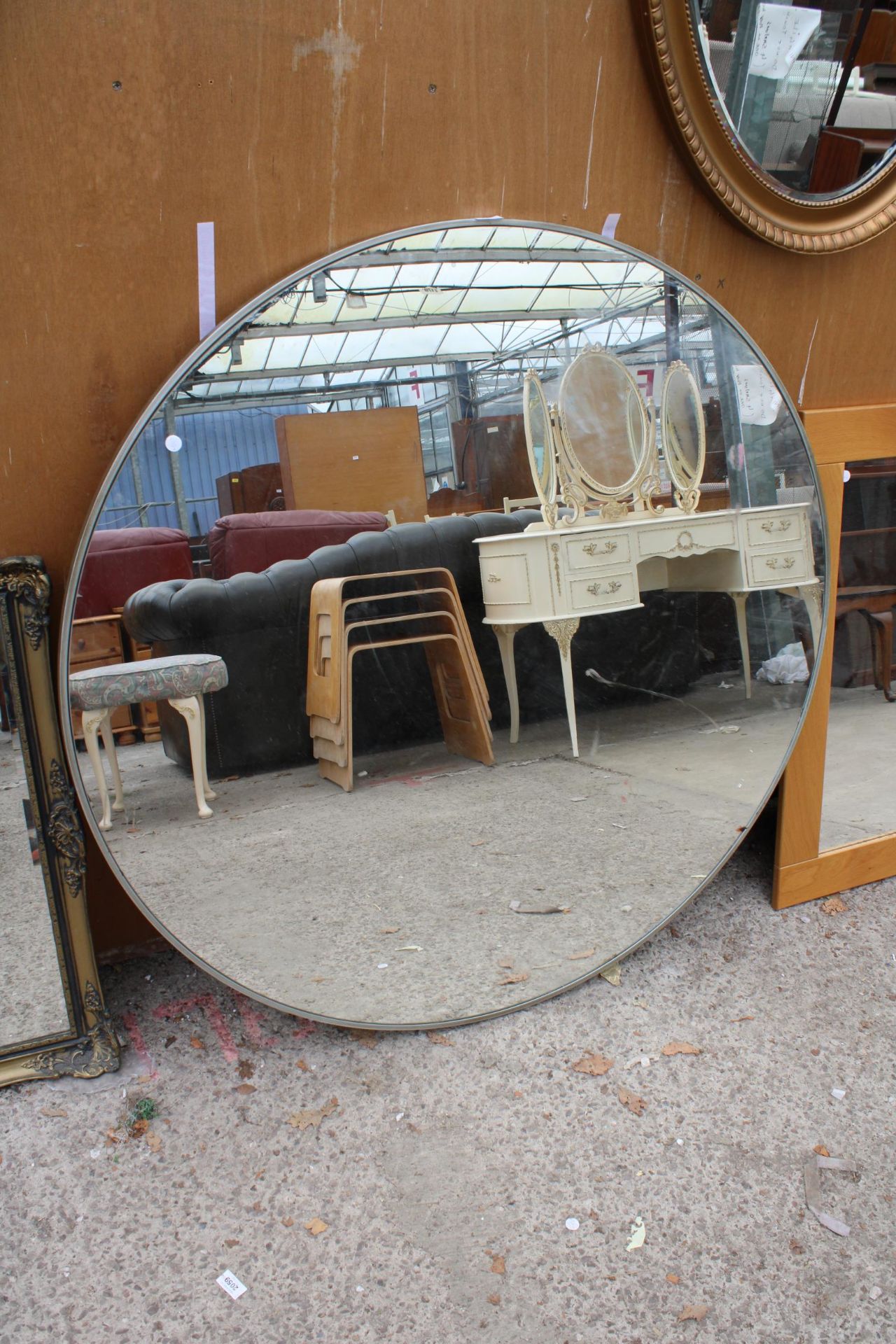 A MODERN METAL FRAMED WALL MIRROR 47" DIAMETER