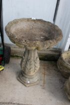 A CONCRETE BIRDBATH WITH PEDESTAL BASE