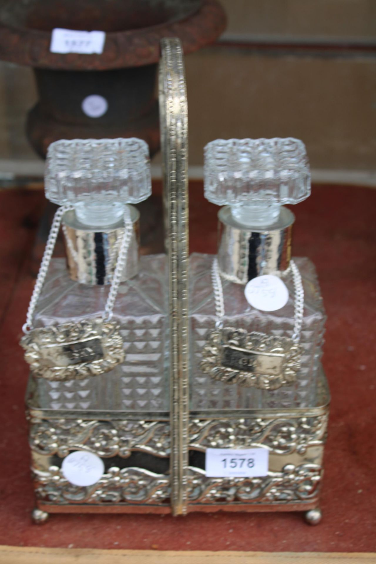 A VINTAGE SILVER PLATED TANTALUS WITH TWO CUT GLASS DECANTORS AND SILVER PLATED LABELS