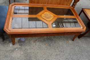 A MODERN OAK AND HARDWOOD COFFEE TABLE WITH INSET GLASS AND CARVED TOP, 52" X 28"