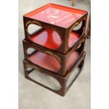 A SET OF THREE ORIENTAL STACKING TABLES WITH CHINOISERIE DECORATION