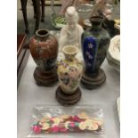 THREE ORIENTAL VASES ON WOODEN STANDS TO INCLUDE CLOISONNE, A SEATED FIGURE, ETC