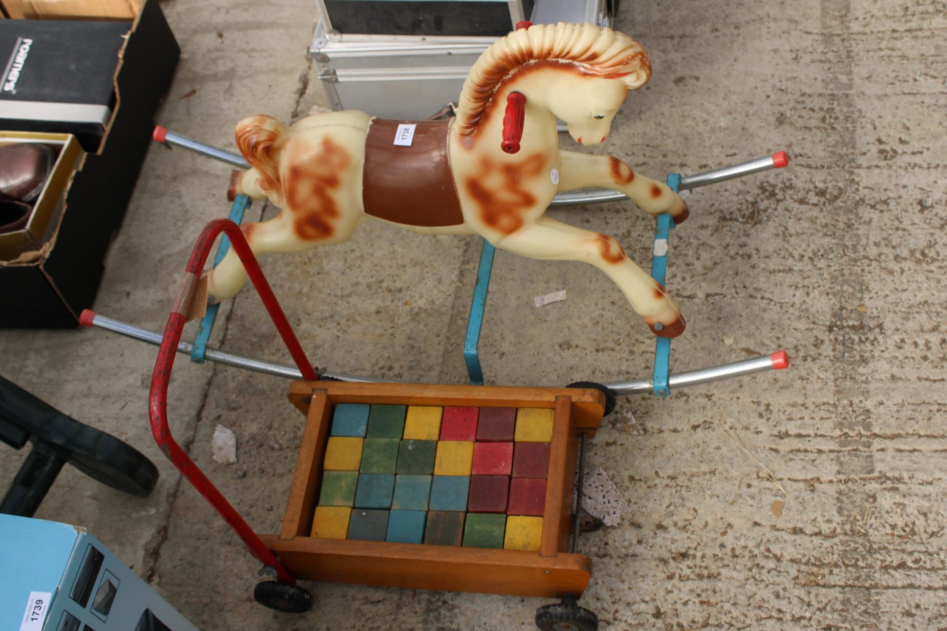A SMALL CHILDS ROCKING HORSE AND A PUSH ALONG TROLLEY WITH WOODEN BLOCKS