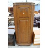 AN EARLY 20TH CENTURY OAK HALL WARDROBE WITH CARVED PANEL DOOR 30" WIDE