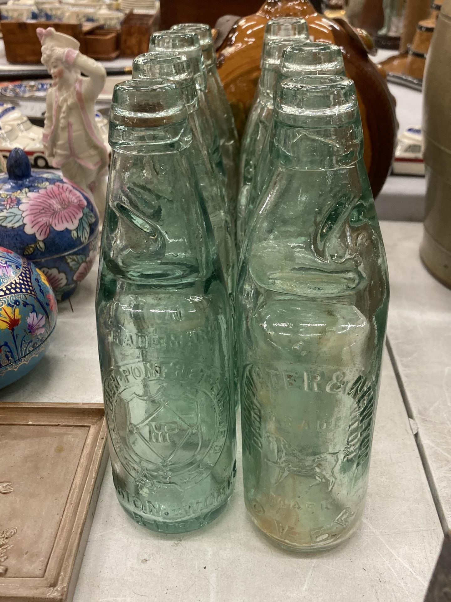 EIGHT GLASS CODD BOTTLES, WITH ADVERTISING TO THE FRONT AND GLASS MARBLE STOPPERS