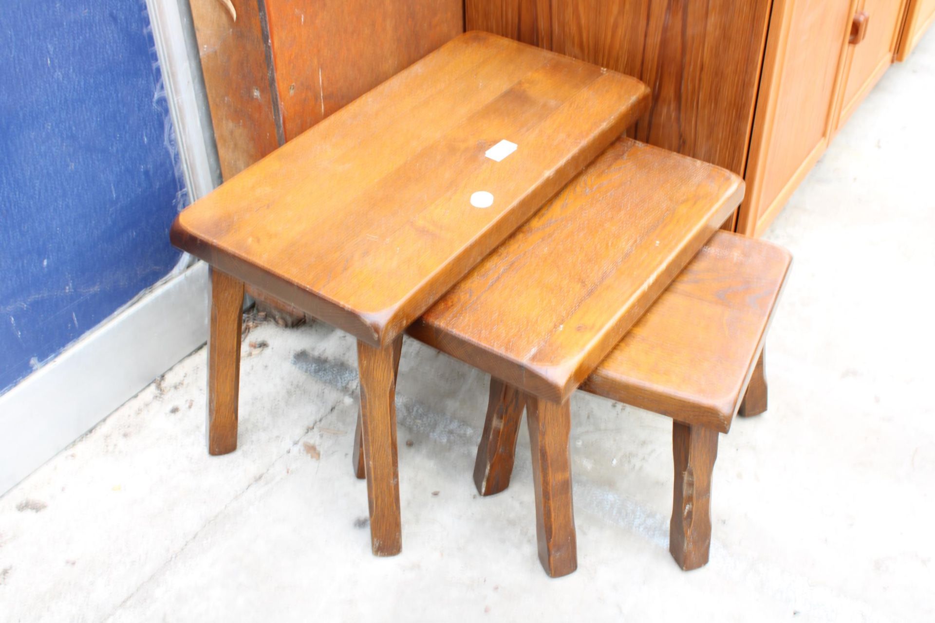 AN OAK NEST OF THREE TABLES ON KICK OUT CHAMFERED LEGS