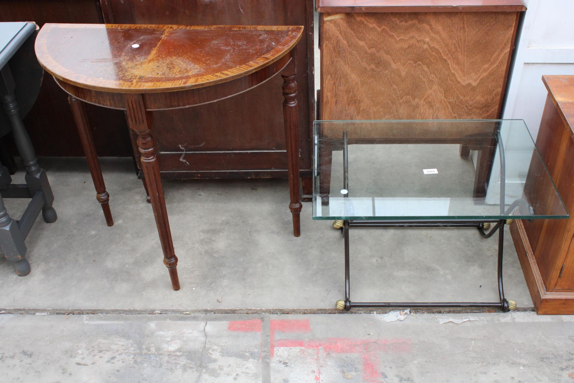 A GLASS TOP COFFEE TABLE ON X FRAME BASE AND A DEMI LUNE HALL TABLE