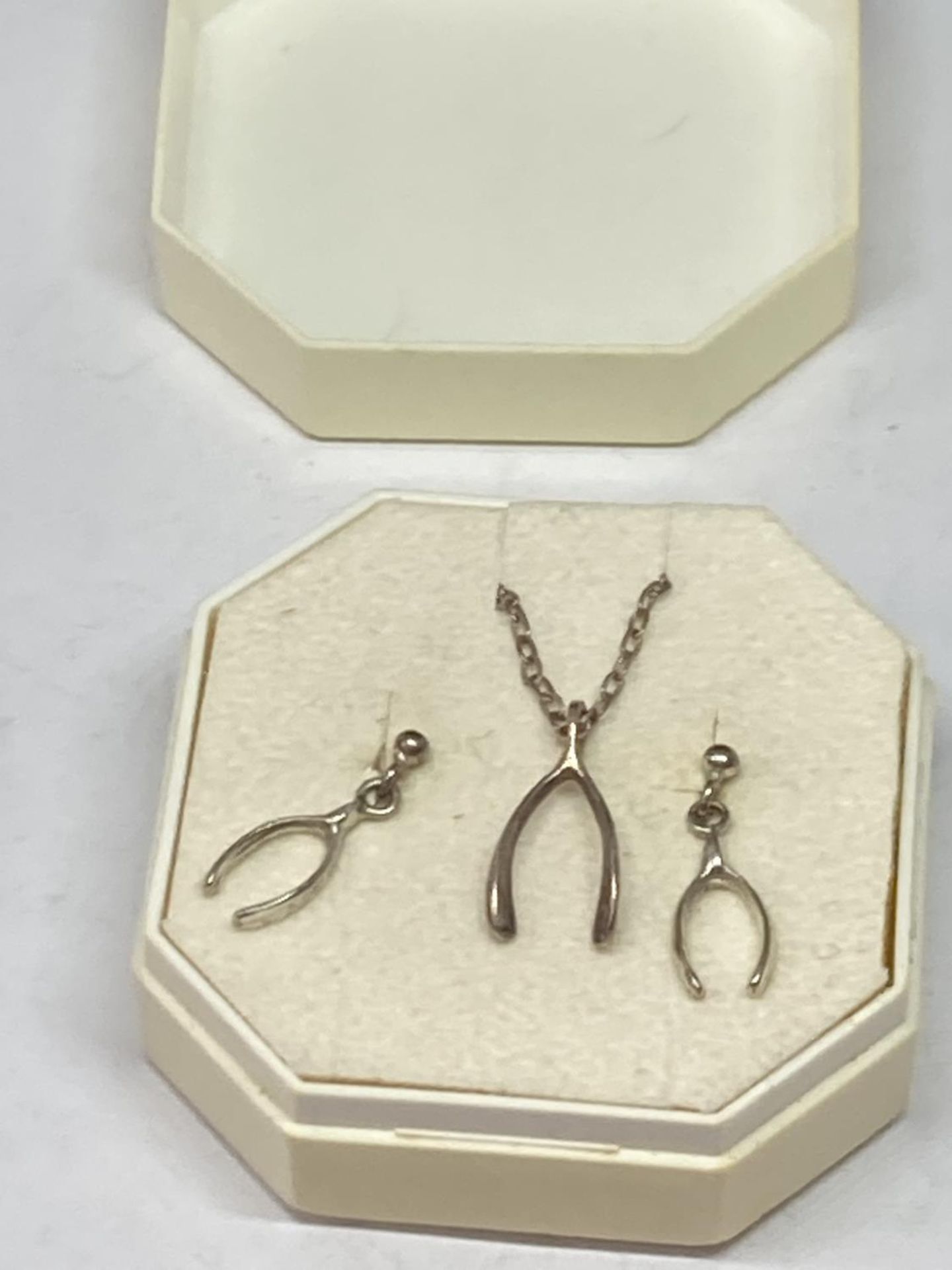A SILVER WISHBONE NECKLACE AND EARRINGS