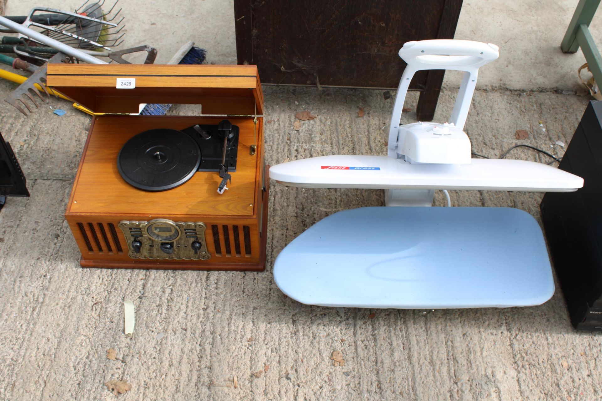 A RETRO STYLE PORTABLE RECORD PLAYER AND A CLOTHES PRESS