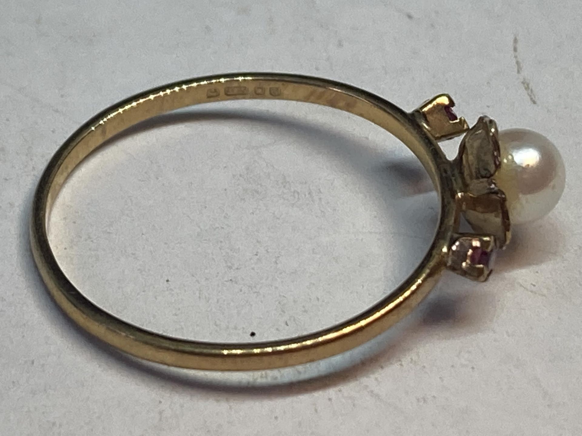 A 9 CARAT GOLD RING WITH SINGLE PEARL AND TWO RED STONES GROSS WEIGHT 1.09 GRAMS SIZE P - Image 2 of 3