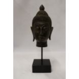 A BUDDAH'S HEAD ON A STAND, HEIGHT 36CM