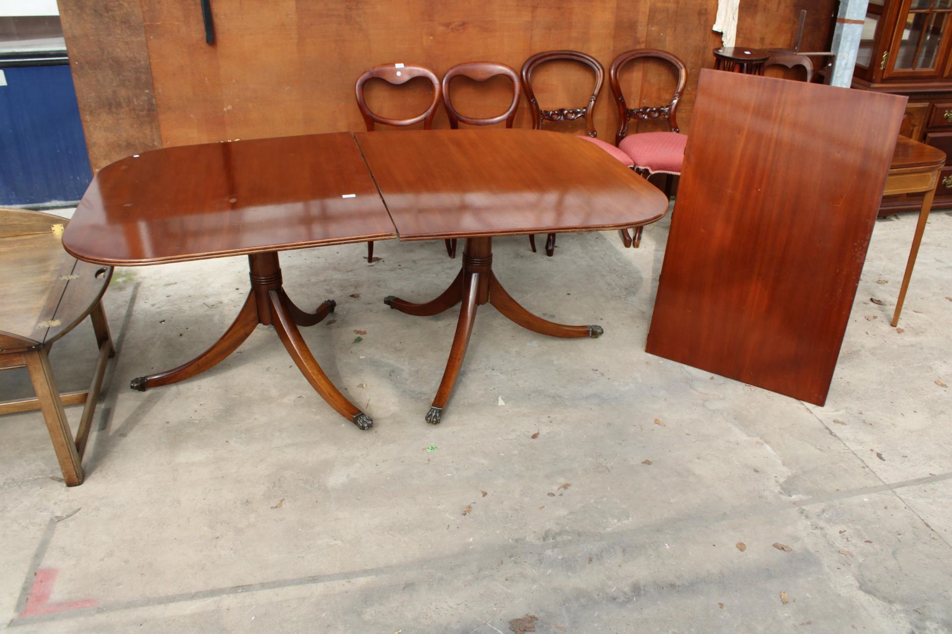A MAHOGANY REGENCY STYLE TWIN PEDESTAL EXTENDING DINING TABLE, 72" X 42" (LEAF 27") ON BRASS CLAW