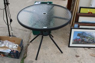 A ROUND METAL AND GLASS TOPPED BISTRO TABLE
