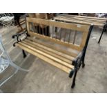 A WOODEN SLATTED GARDEN BENCH WITH CAST BENCH ENDS