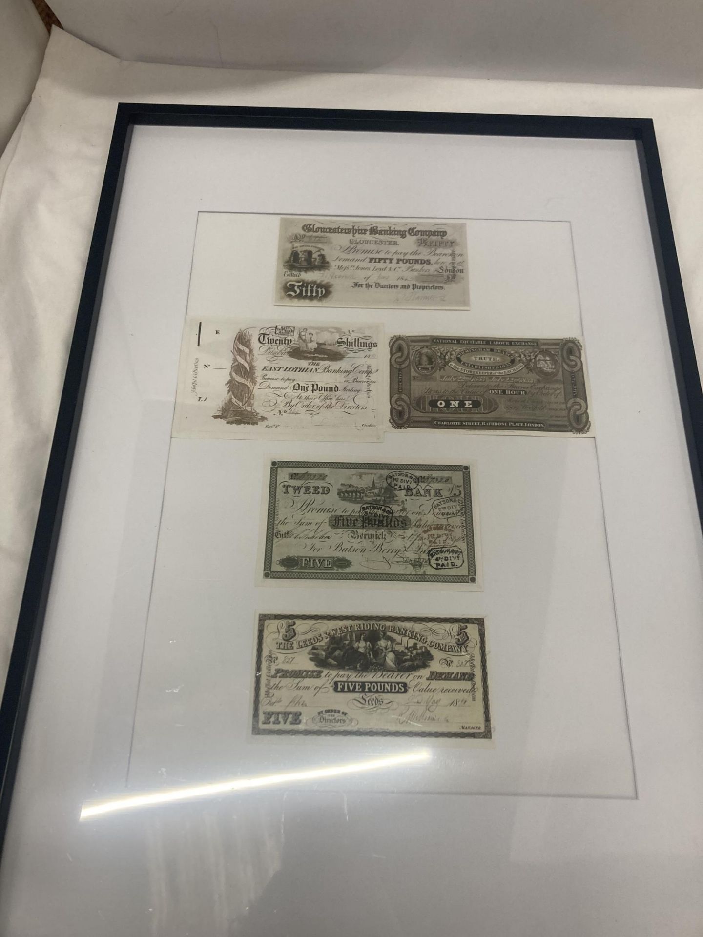 FIVE COPIES OF BANK NOTES, FRAMED