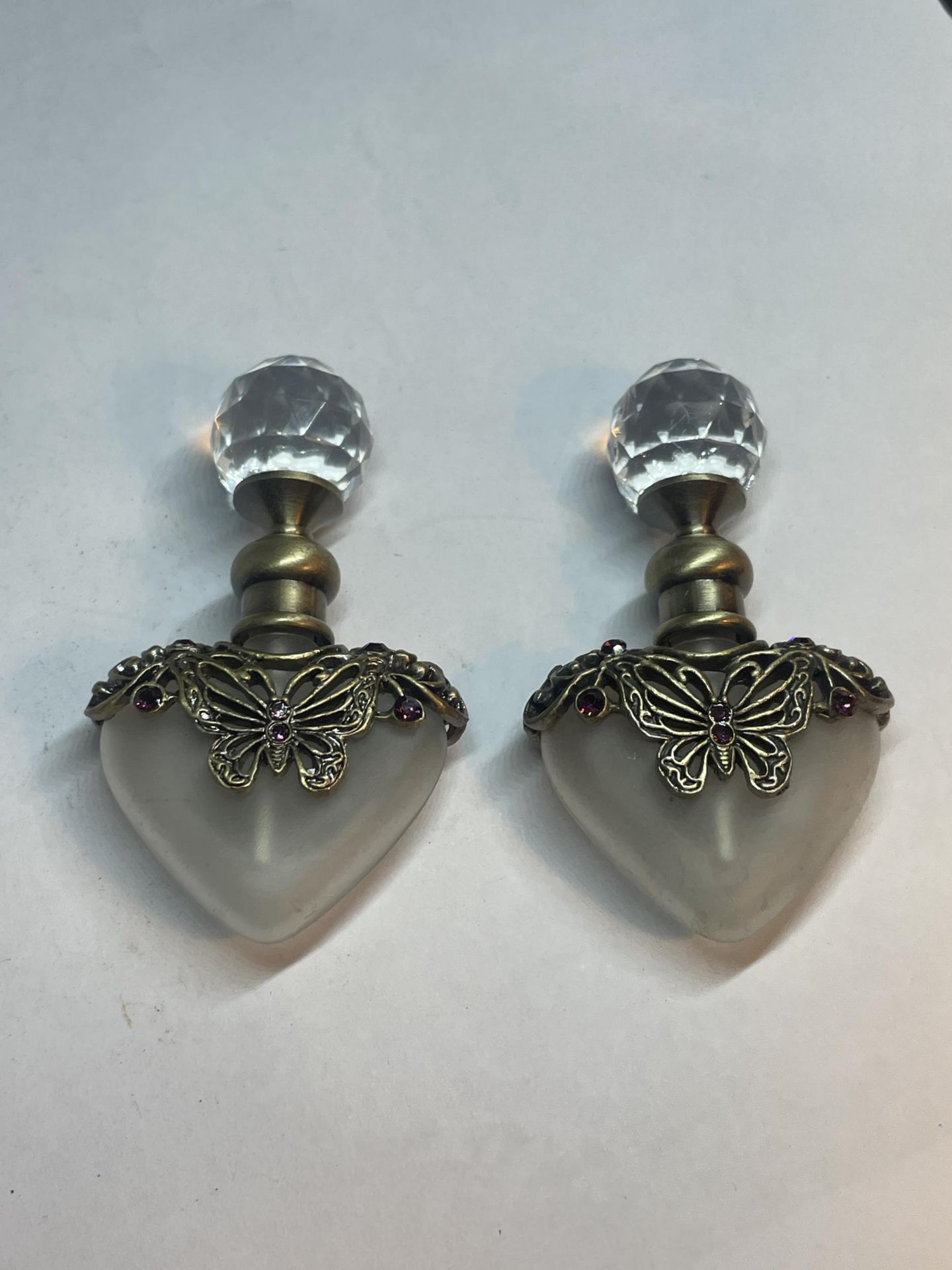 TWO GLASS PERFUME BOTTLES WITH METAL BUTTERFLY DESIGN