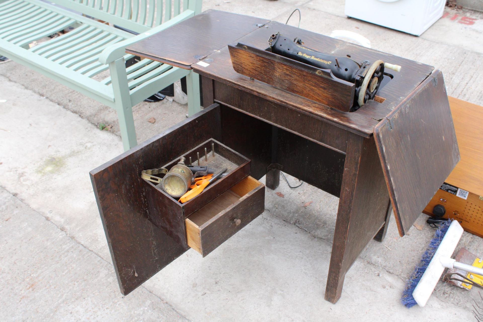 A VINTAGE SINGER SEWING MACHINE WITH WOODEN WORK TABLE