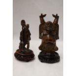 TWO CARVED WOODEN ORIENTAL FIGURES TO INCLUDE A LAUGHING BUDDAH, ON STANDS
