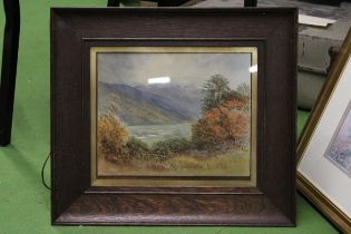 A FRAMED WATERCOLOUR OF A LAKE SCENE